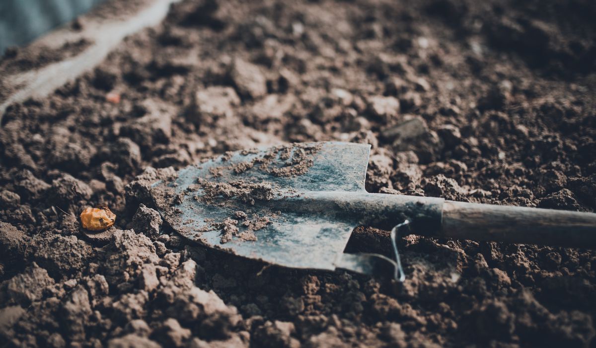 Een spade ligt in pas omgespitte grond